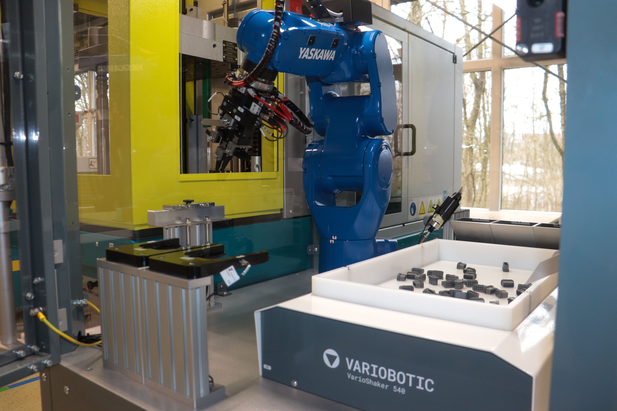 Yaskawa-Roboterarm und VarioShaker integriert an einer Spritzgussmaschine.